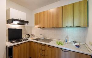 a kitchen with wooden cabinets and a sink at Cozy Apartment In Montemonaco in Montemonaco