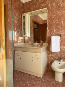 a bathroom with a sink and a toilet and a mirror at Casa7pias in Ponte de Lima