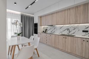 a kitchen with a white table and white chairs at PREVEZA VILLA center in Preveza