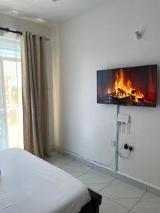 a bedroom with a bed and a fireplace on the wall at Tulivu Comfortable Studio Apartment in Bamburi Mombasa in Mombasa