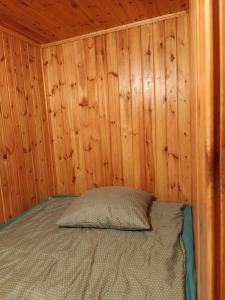 a bedroom with a bed in a wooden wall at Agroturystyka u Edwarda in Karwieńskie Błoto Drugie