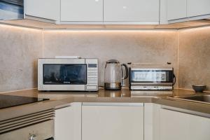 a kitchen with a microwave and a toaster oven on a counter at Poolside Escape - airco & heated pool in Adeje
