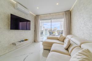 a living room with a couch and a tv at Poolside Escape - airco & heated pool in Adeje