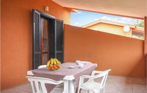 a table with a bowl of fruit on a balcony at Awesome Apartment In Costa Rei -Ca- With Wifi in Monte Nai