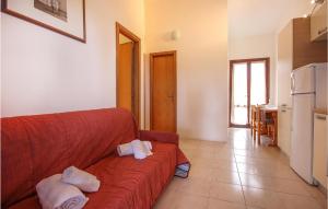 a living room with a red couch with towels on it at Awesome Apartment In Costa Rei -Ca- With Wifi in Monte Nai
