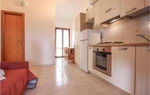 a large kitchen with white appliances and a room at Awesome Apartment In Costa Rei -Ca- With Wifi in Monte Nai +7 photos