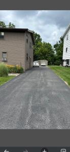 a driveway with two cars parked in a garage at 105 Robert Drive in Syracuse