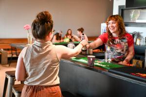 a woman shaking hands with a girl at a counter at City Trip Hostels Amsterdam-Zaandam in Zaandam