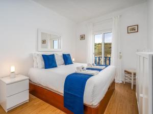 una camera da letto con un letto grande con cuscini blu di Retreat with sea view #1972 a Budens