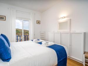 una camera da letto con un grande letto bianco con una finestra di Retreat with sea view #1972 a Budens