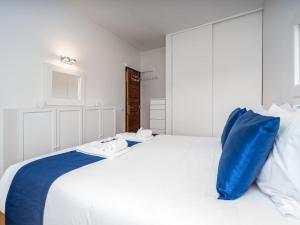 un grande letto bianco con un cuscino blu sopra di Retreat with sea view #1972 a Budens
