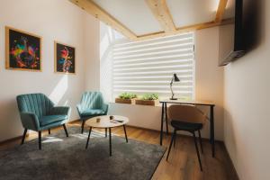 two chairs and a table in a room with a window at Bambi Boutique Rooms - Loftové izby 300 m od centra Banskej Bystrice, Self check-in in Banská Bystrica