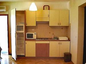 Una cocina con gabinetes blancos y un microondas. en Srima apartments 20 meters from the beach, en Srima