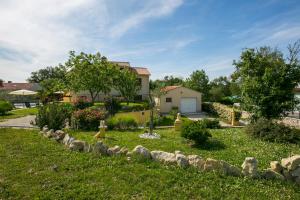 a yard with a retaining wall and a house at Mobile Homes Romantik in Labin
