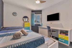 a bedroom with a bed and a desk and a tv at Casa Betta in Costa Calma +19 photos