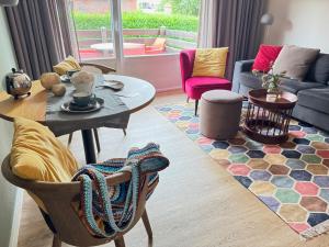 a living room with a table and chairs at Antares Spiekerooger Gästehaus-Sonnengartenterrasse West - Wohnung 2 in Spiekeroog