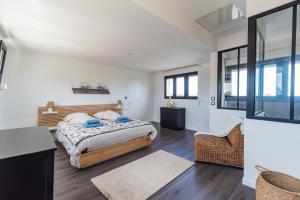a bedroom with a bed and a desk in a room at La Villa des Horizons - Piscine Privée in Plouguiel +17 photos