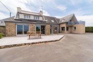 a house with a bench on a wooden deck at La Villa des Horizons - Piscine Privée in Plouguiel