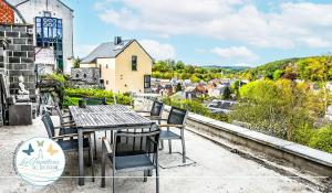 a table and chairs on a patio overlooking a city at Les Papillons de l'Eau d'Heure - charmant gîte près des lacs in Walcourt