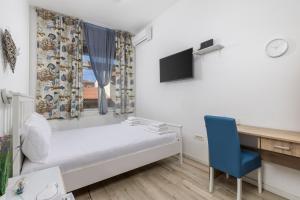 a bedroom with a bed and a blue chair at Fluminis rooms in Rijeka