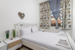 a bedroom with a white bed and a window at Fluminis rooms in Rijeka