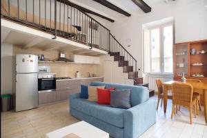 a living room with a blue couch and a kitchen at Downtown loft in Naples in Naples