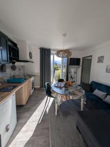 a kitchen and living room with a table and a couch at Le Jardin Secret, Vue sur le château & Parking in Foix
