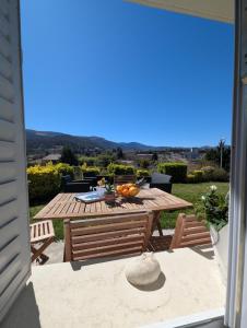 a wooden table with a bowl of fruit on a patio at Le Jardin Secret, Vue sur le château & Parking in Foix