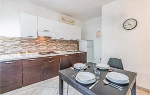 a kitchen with a table and chairs and a clock on the wall at La Piazzetta in Rosolina Mare
