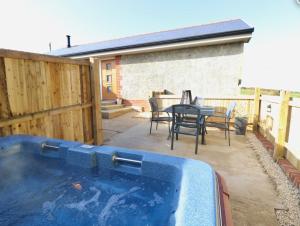 a swimming pool in a backyard with a table and chairs at The Pepper pot in Niton
