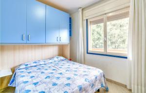 a bedroom with blue cabinets and a bed and a window at La Piazzetta in Rosolina Mare