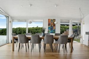 a dining room with a wooden table and chairs at Newly Renovated Holiday Home With Aarhus Bay Views in Rønde