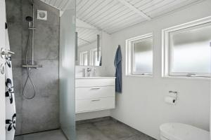 a white bathroom with a shower and a sink at Newly Renovated Holiday Home With Aarhus Bay Views in Rønde +23 photos