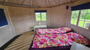 a bedroom with two beds in a wooden cabin at Järvevaatega Puhkemajake in Nüpli