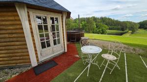 a patio with chairs and a grill on a house at Järvevaatega Puhkemajake in Nüpli +3 photos