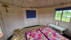 a bedroom with a bed and a desk in a room at Järvevaatega Puhkemajake in Nüpli
