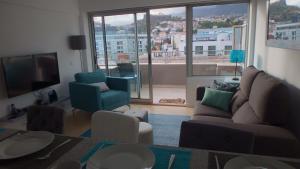 a living room with a couch and a large window at Arriaga apartment in Funchal