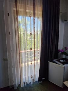 a window with white curtains in a room at Casa Luca in Sulina
