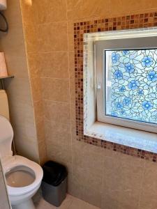 a bathroom with a toilet and a mosaic window at Art Lux Studio 1 in Burgas City