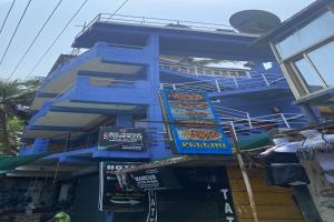 un edificio azul con señales en el costado en Hotel O Red Rock Guest House, en Arambol