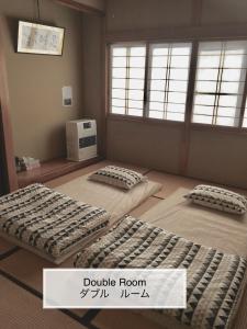 a room with three beds in a room with a window at Winter Season - 民泊 Matsuo House in Zao Onsen - Japanese Style - Private Room in Zao Onsen