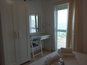 ein Schlafzimmer mit Bett, Schreibtisch und Fenster in der Unterkunft Studios Arto in Pefkari