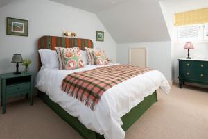 a bedroom with a large bed with a striped headboard at Windy Cottage, Coldstream in Coldstream