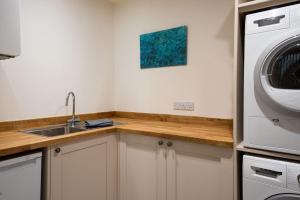 a kitchen with a sink and a washing machine at Windy Cottage, Coldstream in Coldstream