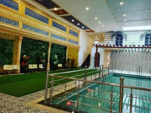 a large swimming pool in a building with a pool at RAJWADA RESORT & HOTEL in Raipur +10 photos