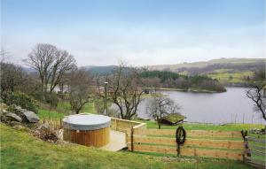 a wooden deck with a hot tub next to a lake at Pet Friendly Apartment In Sandnes in Sandnes
