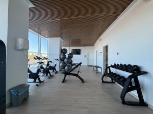 una palestra con file di attrezzi ginnici in una stanza di Gran Canet Salva, moderno apartamento con terraza y vistas al mar a Canet de Berenguer