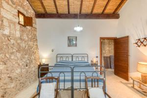 Un dormitorio con una cama y una pared de piedra. en Tenuta Pizzola, en Nociglia
