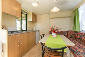 a small kitchen with a table with a green table cloth at Mobile Homes Romantik in Labin