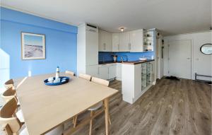 a kitchen and dining room with blue walls and a wooden table at Beautiful Apartment In Uggdal With House Sea View in Uggdal
